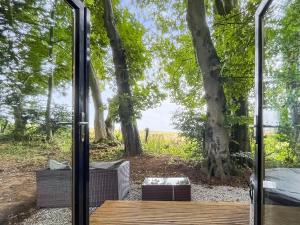 a glass door leading to a patio with trees at Coastal Views in Cloughton