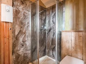 a shower with a glass door in a bathroom at Coastal Views in Cloughton