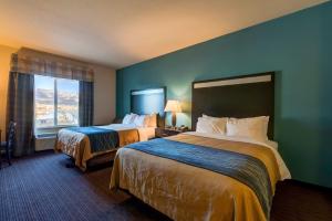 a hotel room with two beds and a window at Grand Vista Hotel Parachute in Parachute +19 photos