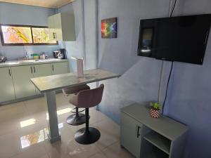 a kitchen with a table and a television and a chair at Apartamento DesCANsO #3 in Comunidad