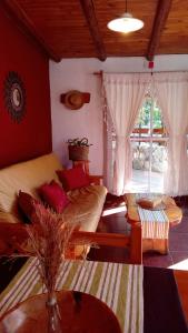 a living room with a couch and a table at Cabañas Flor De Lis in Valle Hermoso