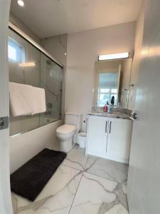a bathroom with a toilet and a shower and a sink at Comfortable Private Room in a Shared Home in Richmond