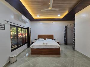 a bedroom with a bed and a ceiling fan at Private Beach - Exotic Sea View Resort in Ganpatipule