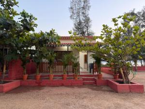 a house with potted trees in front of it at Private Beach - Exotic Sea View Resort in Ganpatipule