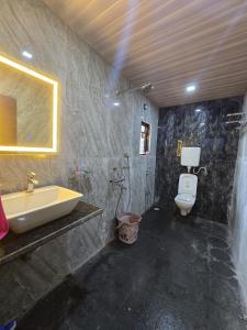 a bathroom with a sink and a toilet at Private Beach - Exotic Sea View Resort in Ganpatipule