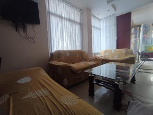 a hospital room with a chair and a glass table at Hotel Viraat Inn Gaya in Gaya