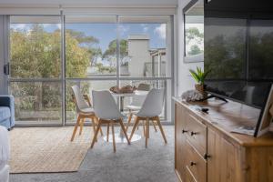 a kitchen with a table and chairs and a large window at Bay View Ocean Breeze in Lorne