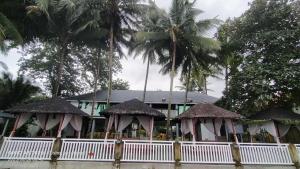 a building with palm trees in front of it at Lantau Beach Resort in Tukuran