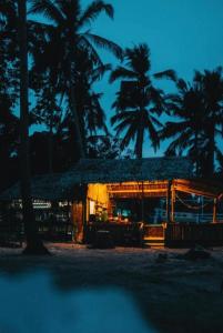 ein Feriengebäude mit Palmen bei Nacht in der Unterkunft MORE Beach in El Nido