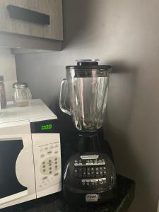 Ein Mixer steht auf der Arbeitsfläche neben einer Mikrowelle. in der Unterkunft Loft B in Mexicali