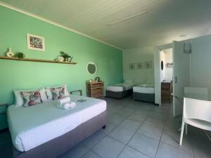 a bedroom with a bed and a room with a table at Forest Gate Apartments and Rooms in Plettenberg Bay