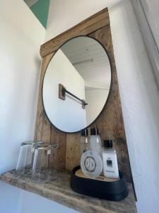 a mirror on top of a shelf with a sink at Forest Gate Apartments and Rooms in Plettenberg Bay