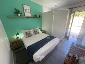 a bedroom with a bed and a blue wall at Forest Gate Apartments and Rooms in Plettenberg Bay +218 photos