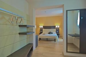 a hotel room with a bed and a mirror at Zen Hotel Versilia in Marina di Pietrasanta