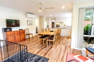 a kitchen and dining room with a wooden table and chairs at Hargreaves House in Bright