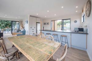 a kitchen and dining room with a wooden table and chairs at Pohara's Beach Escape in Pohara