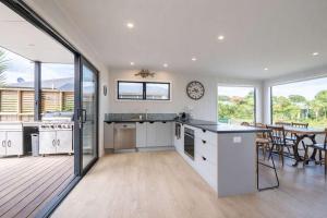 a kitchen and dining room with a clock on the wall at Pohara's Beach Escape in Pohara
