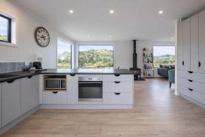 a kitchen with white cabinets and a counter top at Pohara's Beach Escape in Pohara