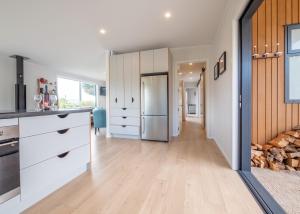 a kitchen with white cabinets and a refrigerator at Pohara's Beach Escape in Pohara +7 photos