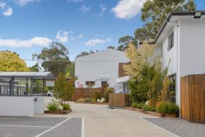 a white house with a courtyard with plants at Bay View Ocean Breeze in Lorne