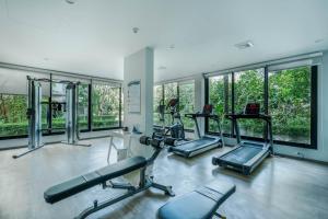 a gym with treadmills and ellipticals in a room with windows at Studio Apartment by the Sea E413 in Phuket