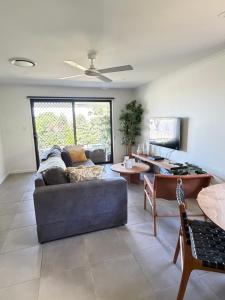 a living room with a couch and a table at JOT Luxe Haven in Narangba