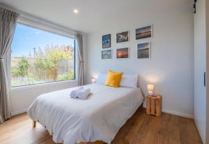 a bedroom with a bed with a large window at Pohara Beach Pukeko Studio in Pohara +3 photos