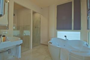 a bathroom with a tub and a sink and a shower at Zen Hotel Versilia in Marina di Pietrasanta