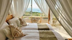 a bedroom with a bed and a large window at Hummocks in Sesoko