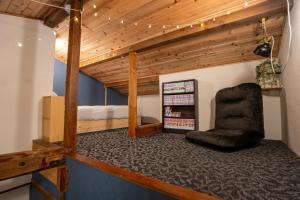a room with a black chair and a bed at sneaky peaks in Hakuba