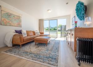 a living room with a couch and a chair at Pohara's Beachside Gem in Pohara