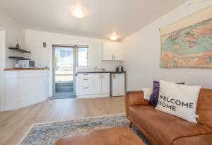 a living room with a couch and a kitchen at Pohara's Beachside Gem in Pohara