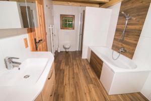 a bathroom with a tub and a sink at Landhof Adlerhorst in Heiligenblut