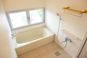 a bathroom with a bath tub and a window at Hummocks in Sesoko +45 photos