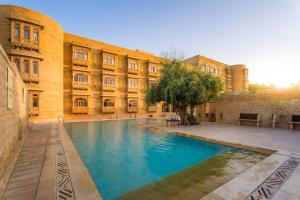 a building with a swimming pool in front of a building at Hotel Golden Haveli in Jaisalmer