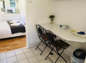 a kitchen with a table and chairs in a room at Ocean Studio along Shelly Beach in Sydney