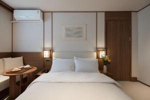 ein Schlafzimmer mit einem großen weißen Bett und einem Tisch in der Unterkunft Hotel Flow-er in Kangnŭng-yŏk + 79 Fotos
