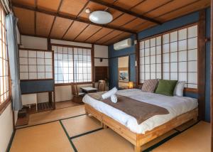 a bedroom with a large bed in a room with windows at sneaky peaks in Hakuba