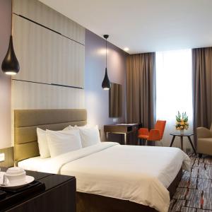 a hotel room with a bed and a desk at Promenade Hotel Bintulu in Bintulu