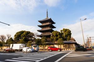 a pagoda with cars parked in front of a street at Oyado Toshi in Kyoto