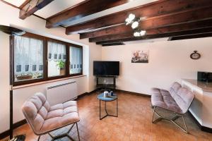 a living room with two chairs and a flat screen tv at Gîte les mésanges in Castres