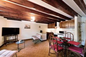 a living room with a table and chairs and a kitchen at Gîte les mésanges in Castres
