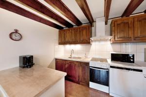 a kitchen with white appliances and wooden cabinets at Gîte les mésanges in Castres