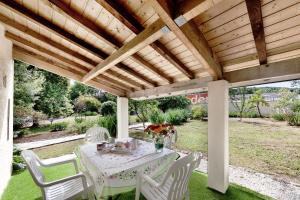 a white table and chairs under a wooden pergola at Gîte les mésanges in Castres +4 photos