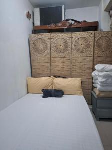 a bedroom with a white bed with a wooden headboard at Lancaster new city in General Trias