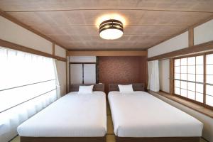 two beds in a room with two windows at APROSTAY Fuji-kawaguchiko Aizen15 in Fujiyoshida