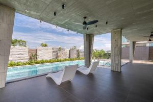 a patio with white chairs and a swimming pool at 135 會館 135 Private Villa Yilan in Dongshan