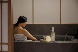 Eine Frau sitzt in einem Spülbecken in der Küche. in der Unterkunft Hotel Flow-er in Kangnŭng-yŏk