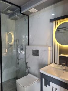 a bathroom with a shower and a toilet and a sink at The Cove Beach Resort in Cochin +58 photos
