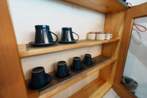 a row of black coffee cups on a wooden shelf at SAMURISE No.4 in Fujikawaguchiko